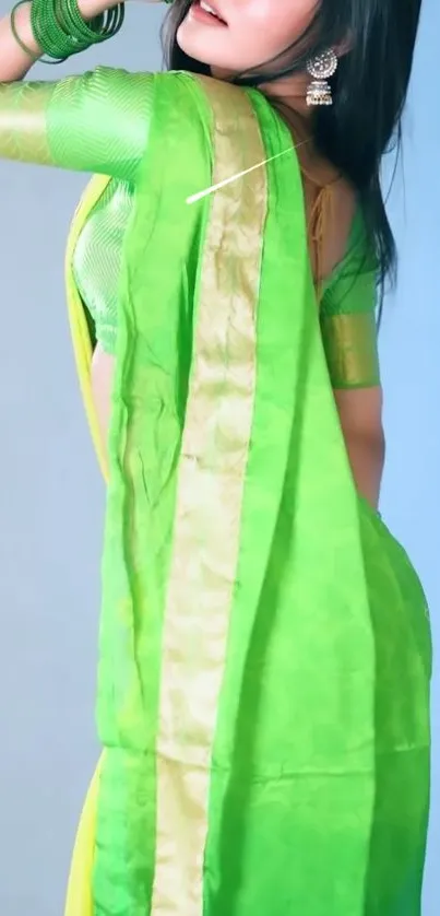 Elegant woman in vibrant green saree posing gracefully.