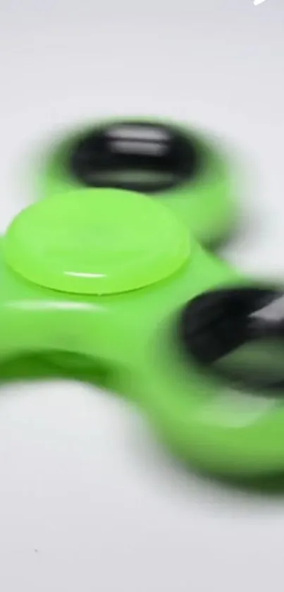 Lime green fidget spinner with black circles.