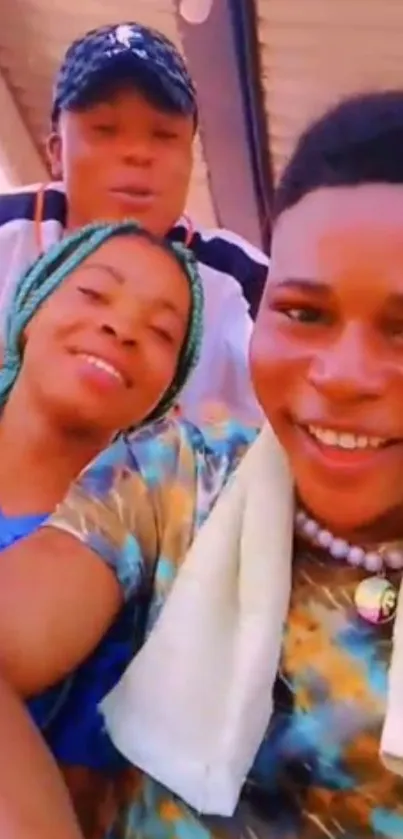 Smiling friends in a colorful group selfie under sunlight.