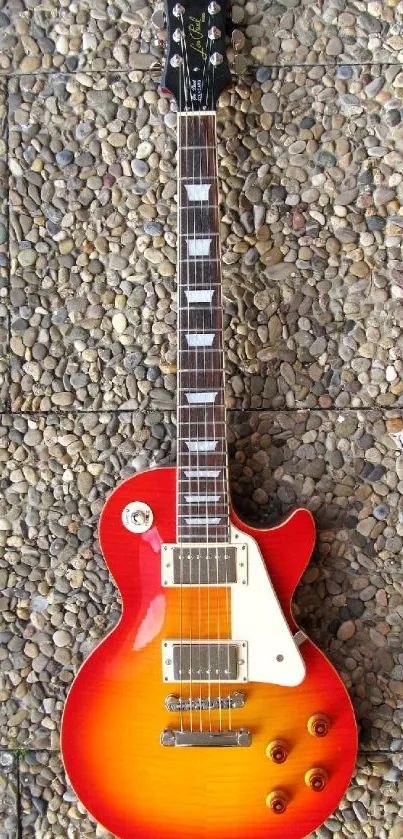 Red and orange electric guitar on stone background.