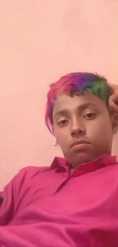 A young person with vibrant multicolored hair and a pink shirt.