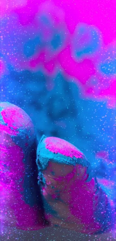 Hand covered in vibrant pink and teal paint, creating a striking visual contrast.