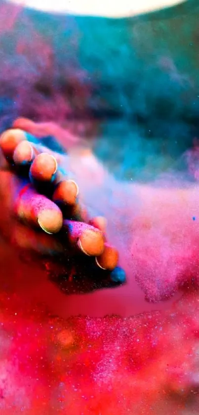 Hand immersed in vibrant colored powder with pink and blue hues.