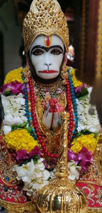 Colorful Hanuman statue with floral garlands.