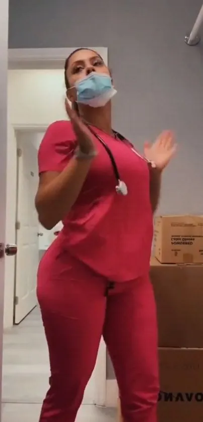 Healthcare professional in pink uniform in a clinic room.