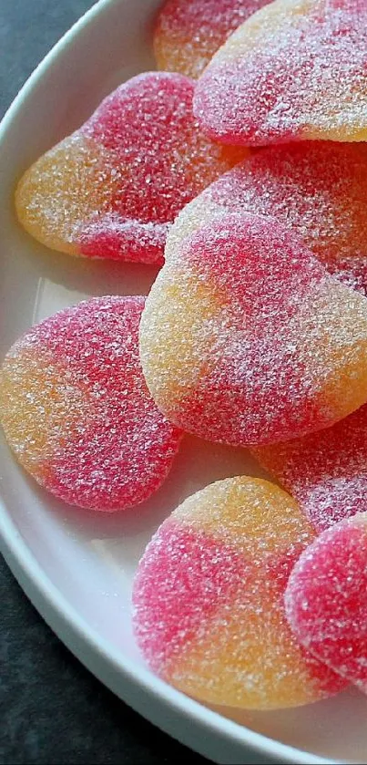 Heart-shaped candies in pink and orange hues on a plate.