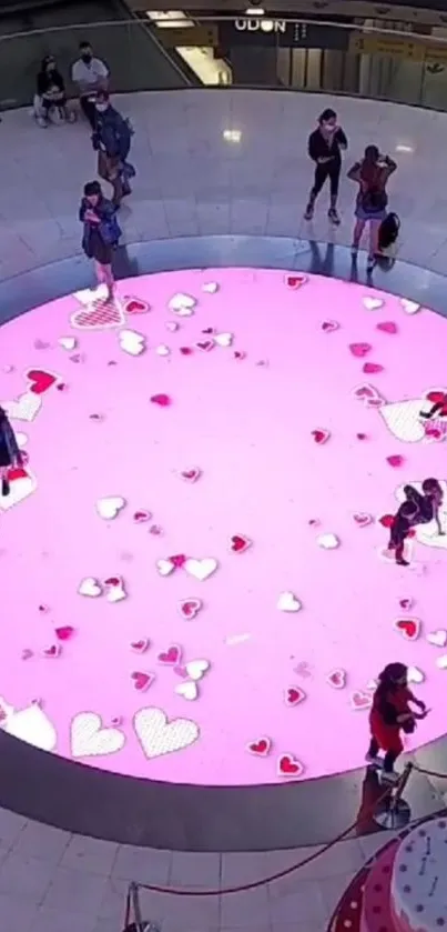 Vibrant pink circle with hearts on a public display.