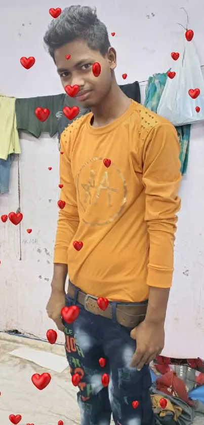 Man in orange shirt with red hearts wallpaper.