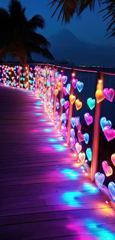 Colorful heart-shaped lights on a boardwalk at night.