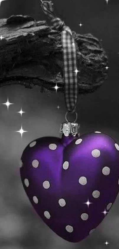 Purple heart ornament with polka dots on a branch.