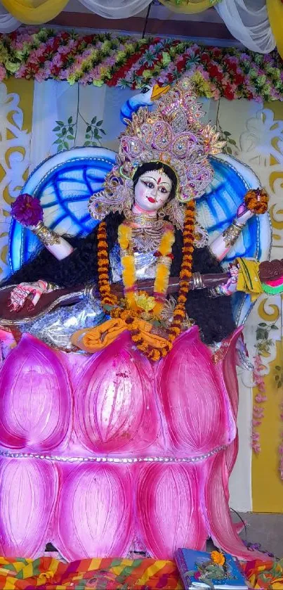 Hindu goddess seated on a pink lotus with floral decorations.