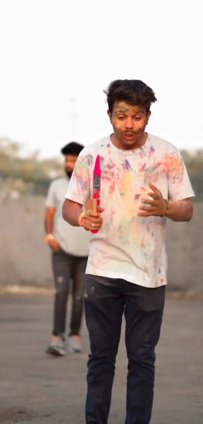 Young man celebrates Holi festival with colorful powders.