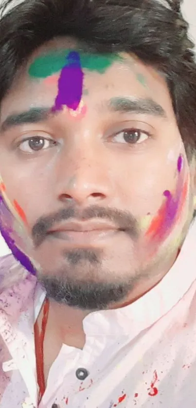 Portrait with vibrant Holi colors on face.