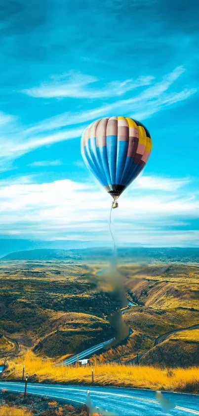 Colorful hot air balloon over scenic landscape under blue sky.
