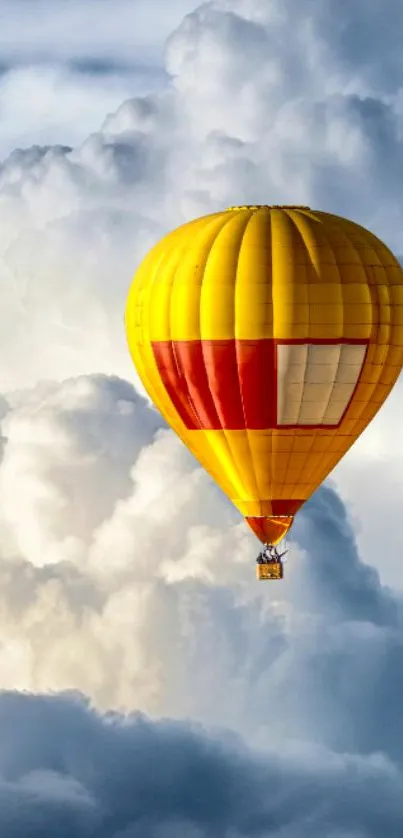 Yellow hot air balloon floating above fluffy clouds.