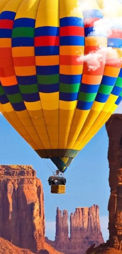Colorful hot air balloon over canyon landscape, vibrant mobile wallpaper.