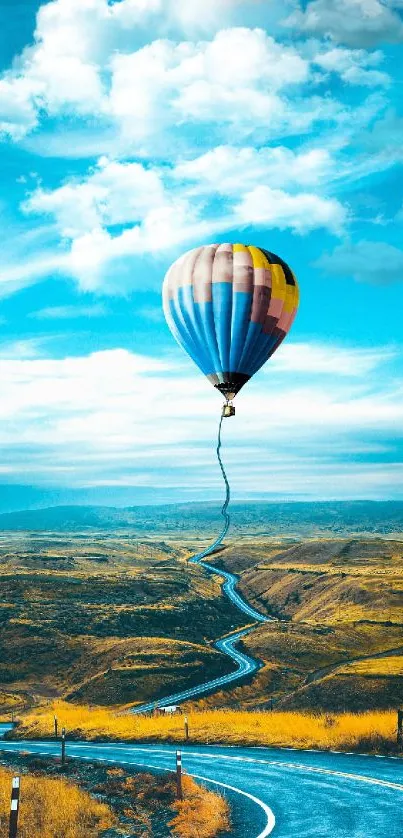 Hot air balloon floating over winding road under vibrant sky.