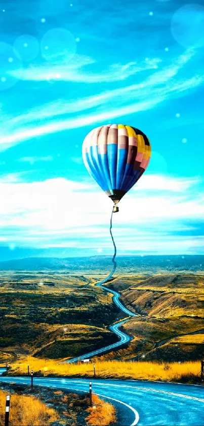 Vibrant hot air balloon over winding road in scenic blue sky landscape.