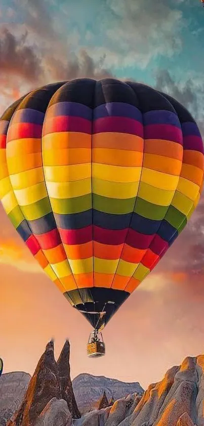 Hot air balloon over colorful sunset landscape.