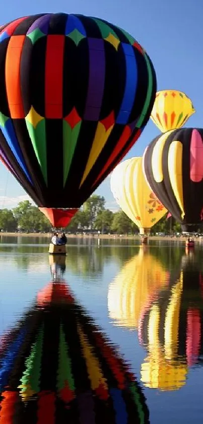 Colorful hot air balloons over a calm lake reflecting the blue sky.