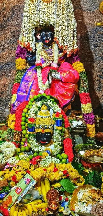 Vibrantly colored Indian deity with flowers and offerings.