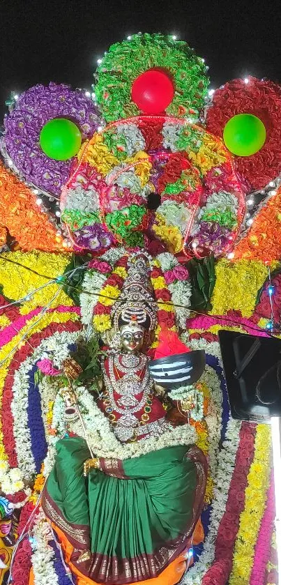 Colorful Indian festival decor with deity and flowers.