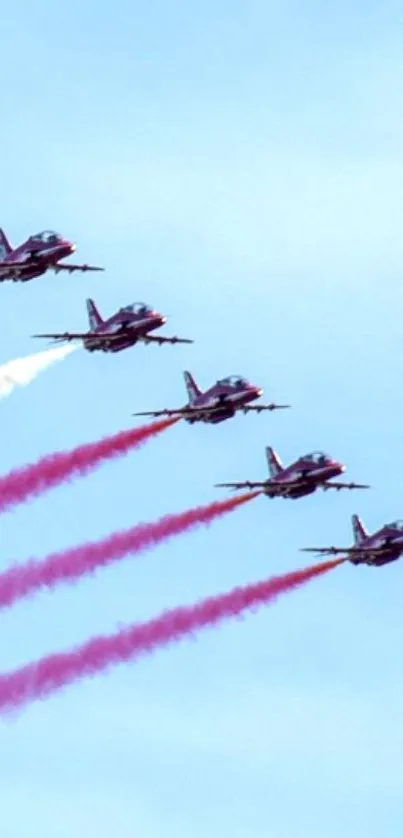 Jets in formation with colorful trails against clear blue sky.