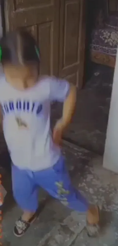 Child energetically dancing on rustic floor.