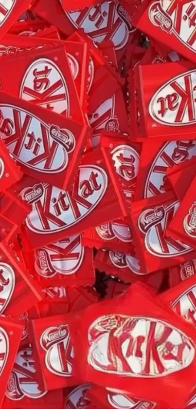 A vibrant pile of KitKat candy wrappers in red and white.