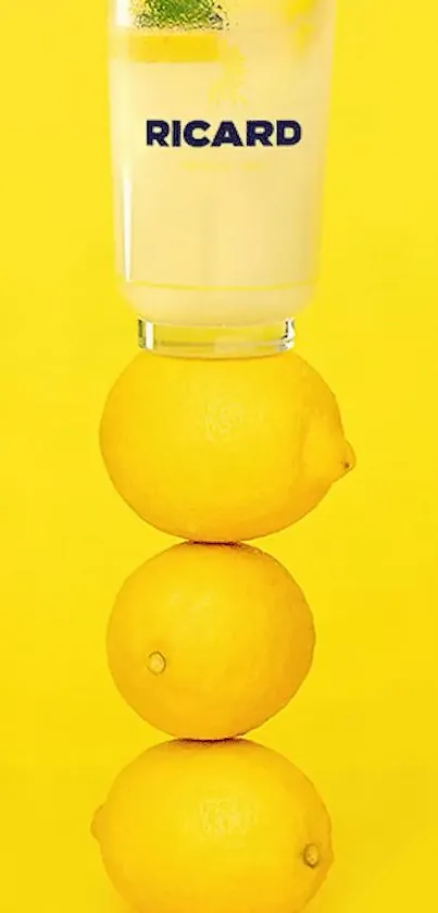 Stack of lemons topped with a glass on vibrant yellow background.