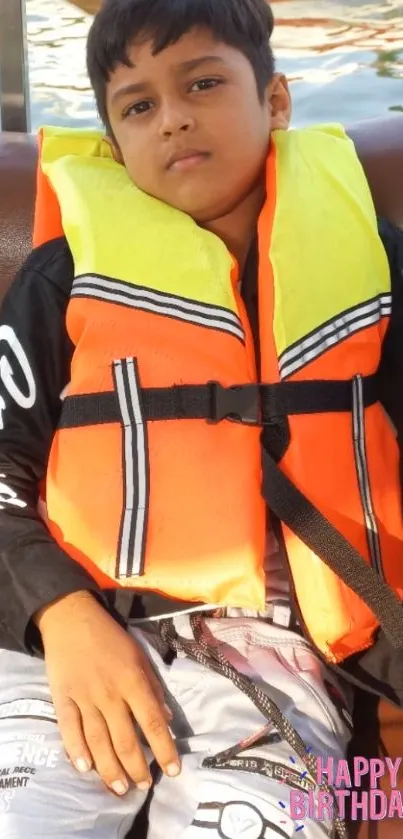 Child in a life jacket on a boat, celebrating a birthday.