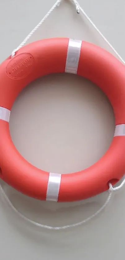 Red lifebuoy on a light wall, minimalistic wallpaper.