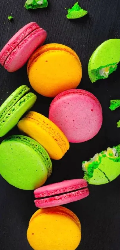 Bright macarons scattered on black background.