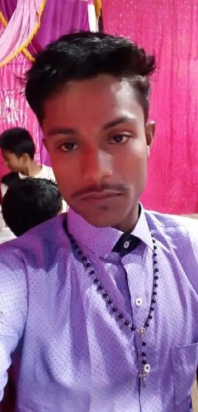 Stylish selfie with magenta background at an event.