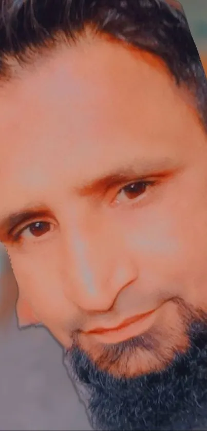 Close-up portrait of a man with a warm skin tone and dark beard.