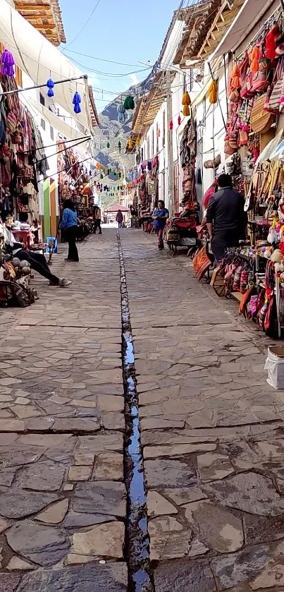 Colorful marketplace on cobblestone street with vibrant goods and bustling activity.