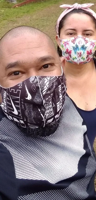 A vibrant duo wearing patterned face masks outdoors.