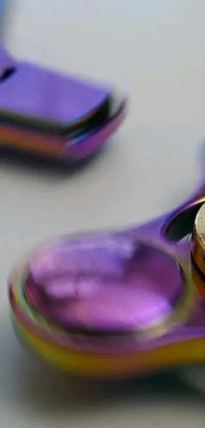 Purple and gold metal fidget spinner on a white surface.