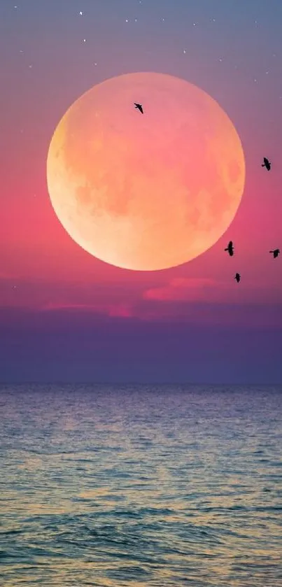 Vibrant pink moon rising over a serene ocean at sunset.