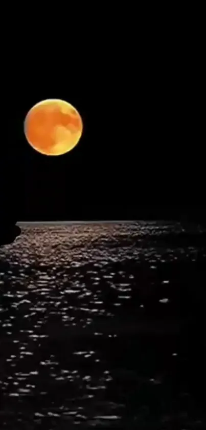 Vivid orange moon over a tranquil moonlit ocean scene.