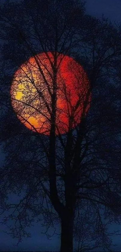 Silhouette of a tree against a red moon on a dark blue night background.