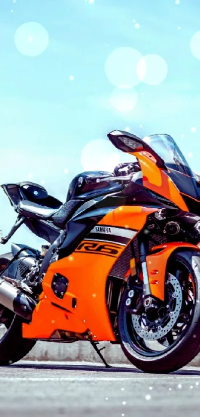 Orange superbike under a blue sky with bokeh.