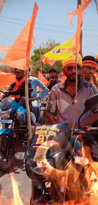 Motorcycle procession with orange flags waving in lively scene.