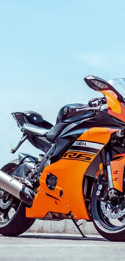 Vibrant orange and black sports motorcycle on the street.