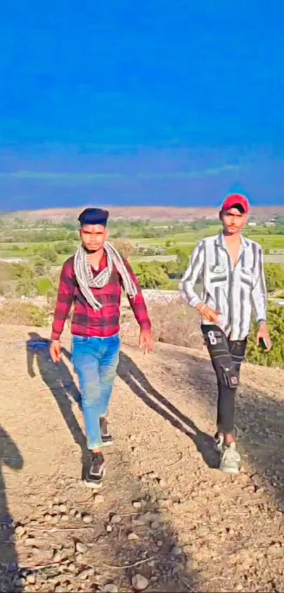 Two friends walking on a scenic nature path under a vibrant blue sky.