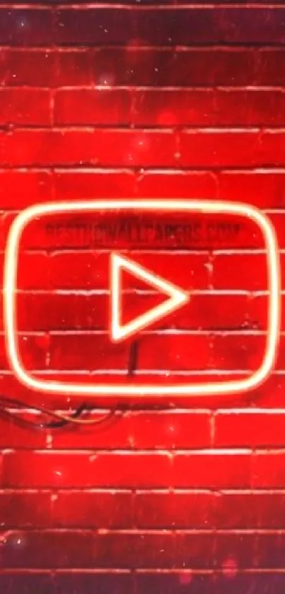 Neon play button glowing on red brick wall.