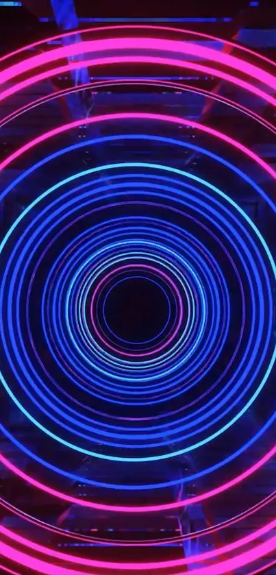 Neon concentric circles in pink and blue colors on a dark background.