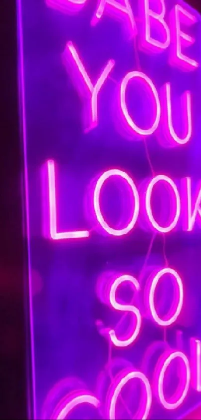 Neon sign reading 'Babe you look so cool' against a purple backdrop.