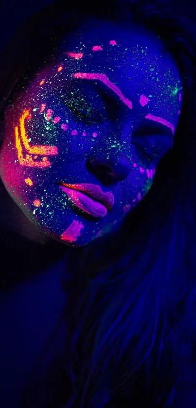 Neon UV face art in dark blue glow.