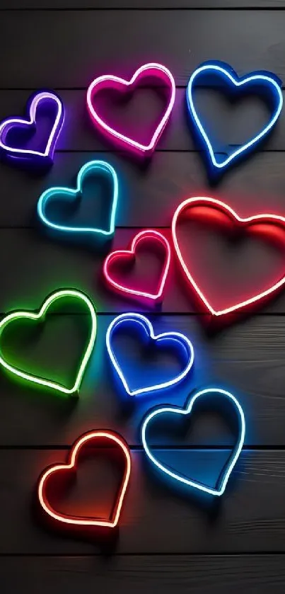 Vibrant neon hearts on dark wood background.